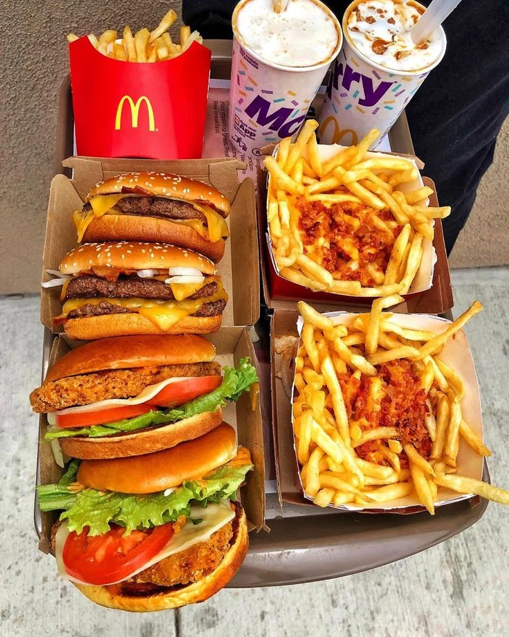 Top-down view of burgers, fries, and drinks on a tray